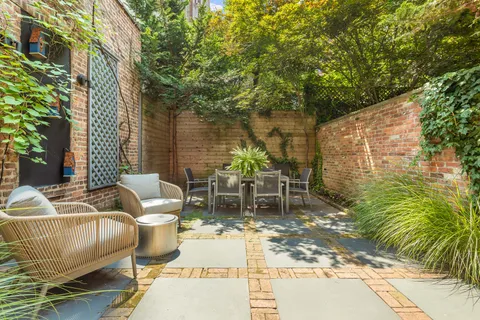 a view of a patio with couches table and chairs and potted plants