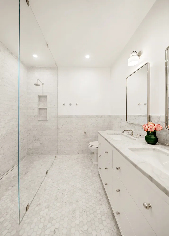 a bathroom with a granite countertop sink a toilet and shower