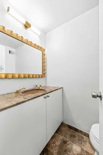 a bathroom with a granite countertop sink and a mirror