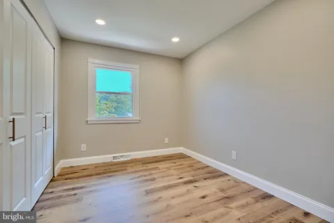 an empty room with wooden floor and window