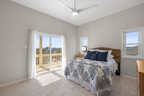 a bedroom with a balcony a bed and a large window with outer view