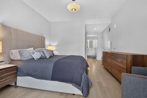 a bedroom with a bed and painting on the wall
