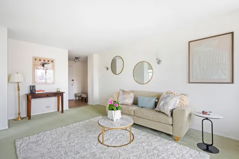 a living room with furniture a rug and a table