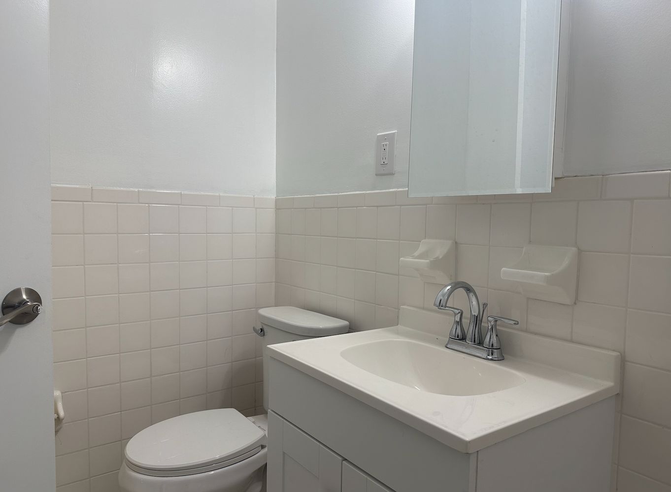 a bathroom with a toilet sink and mirror