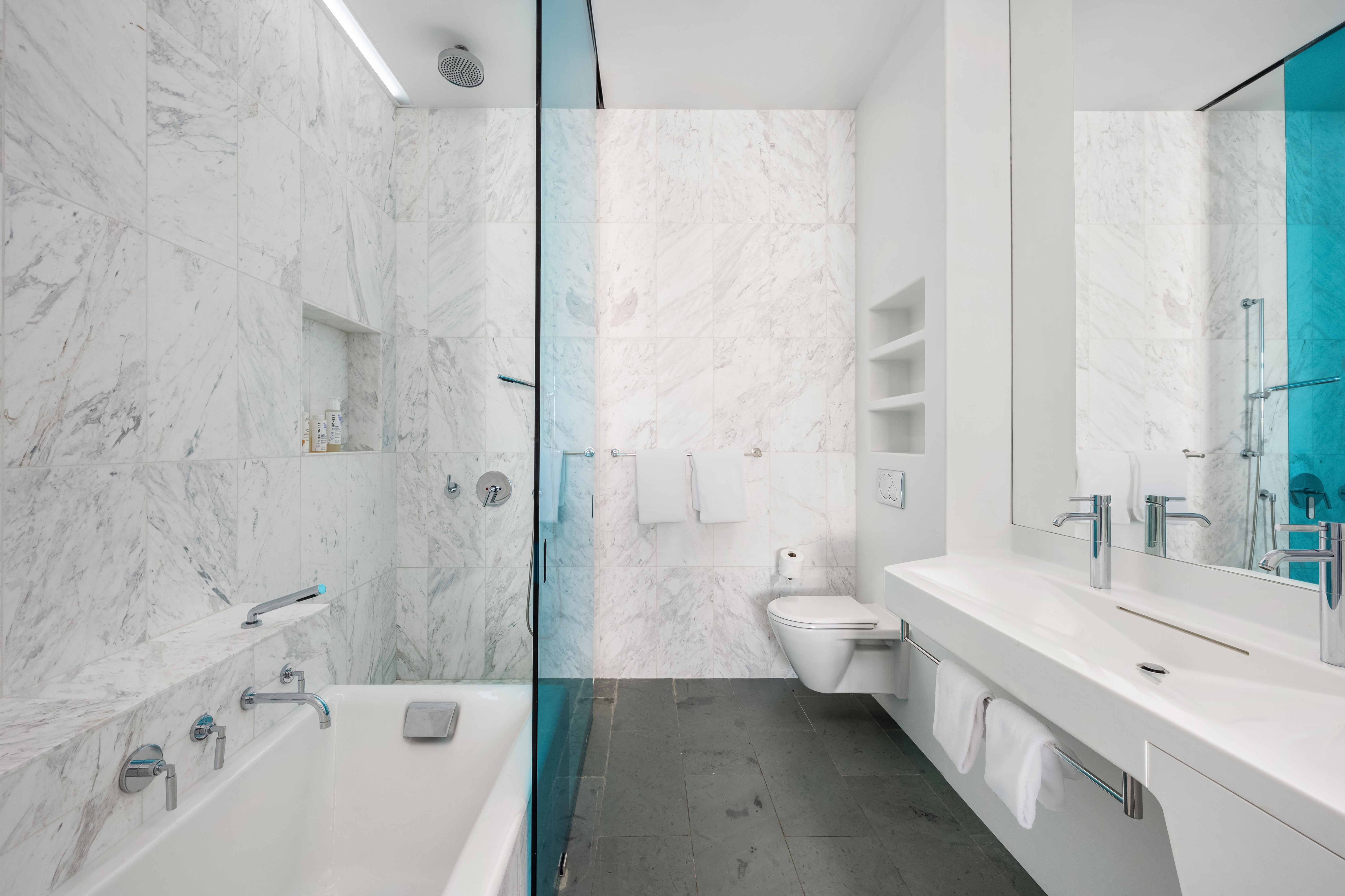 166 Perry Street, Unit 6B Manhattan, NY 10014 - Photo 9 of 17 a bathroom with a double vanity sink toilet and shower