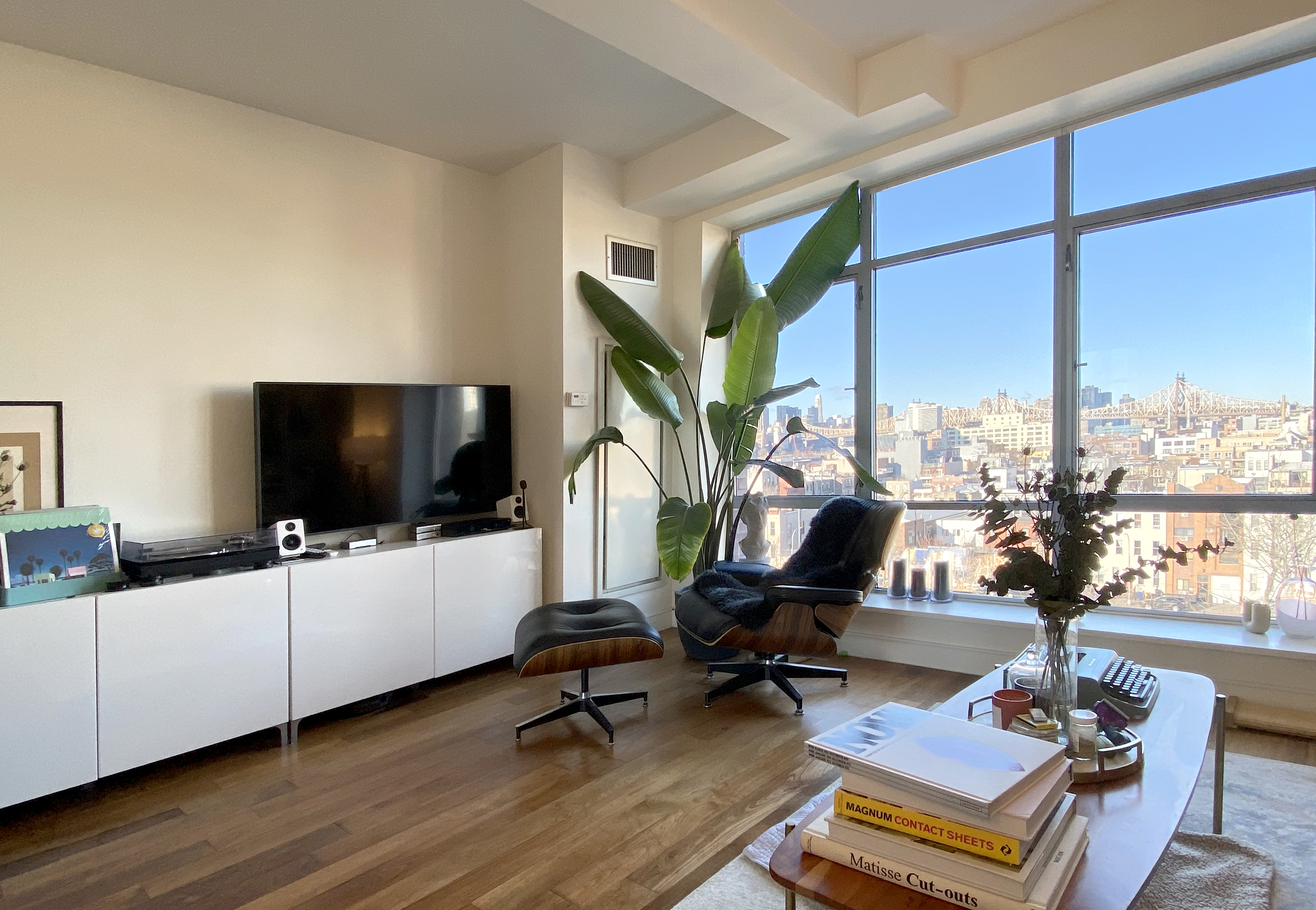 10-63 Jackson Avenue, Unit 7E Queens, NY 11101 - Photo 2 of 6 a living room with furniture flat screen tv and a large window