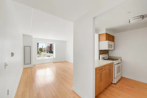a view of a kitchen with a sink wooden floor and a window