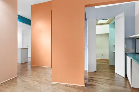 a view of a room with wooden floor and a bathroom