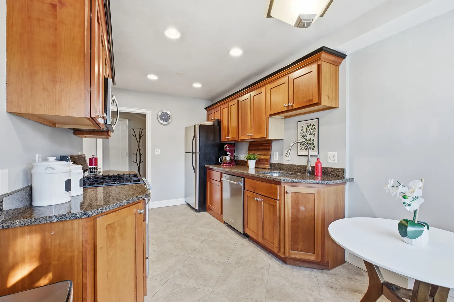 a kitchen with stainless steel appliances granite countertop a sink dishwasher stove refrigerator and cabinets