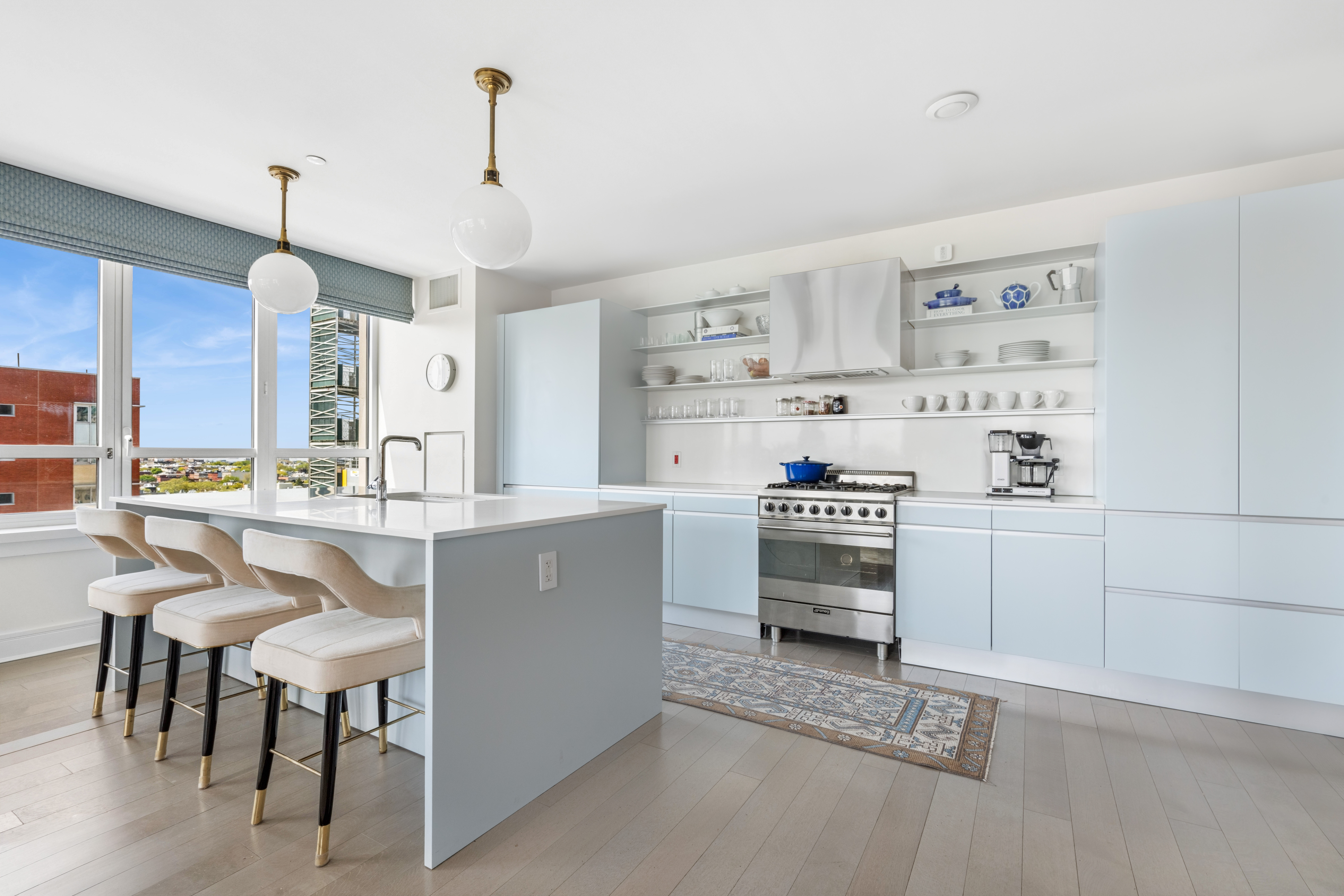 265 State Street, Unit 1201 Brooklyn, NY 11201 - Photo 4 of 19 a kitchen with kitchen island a stove a table and chairs in it