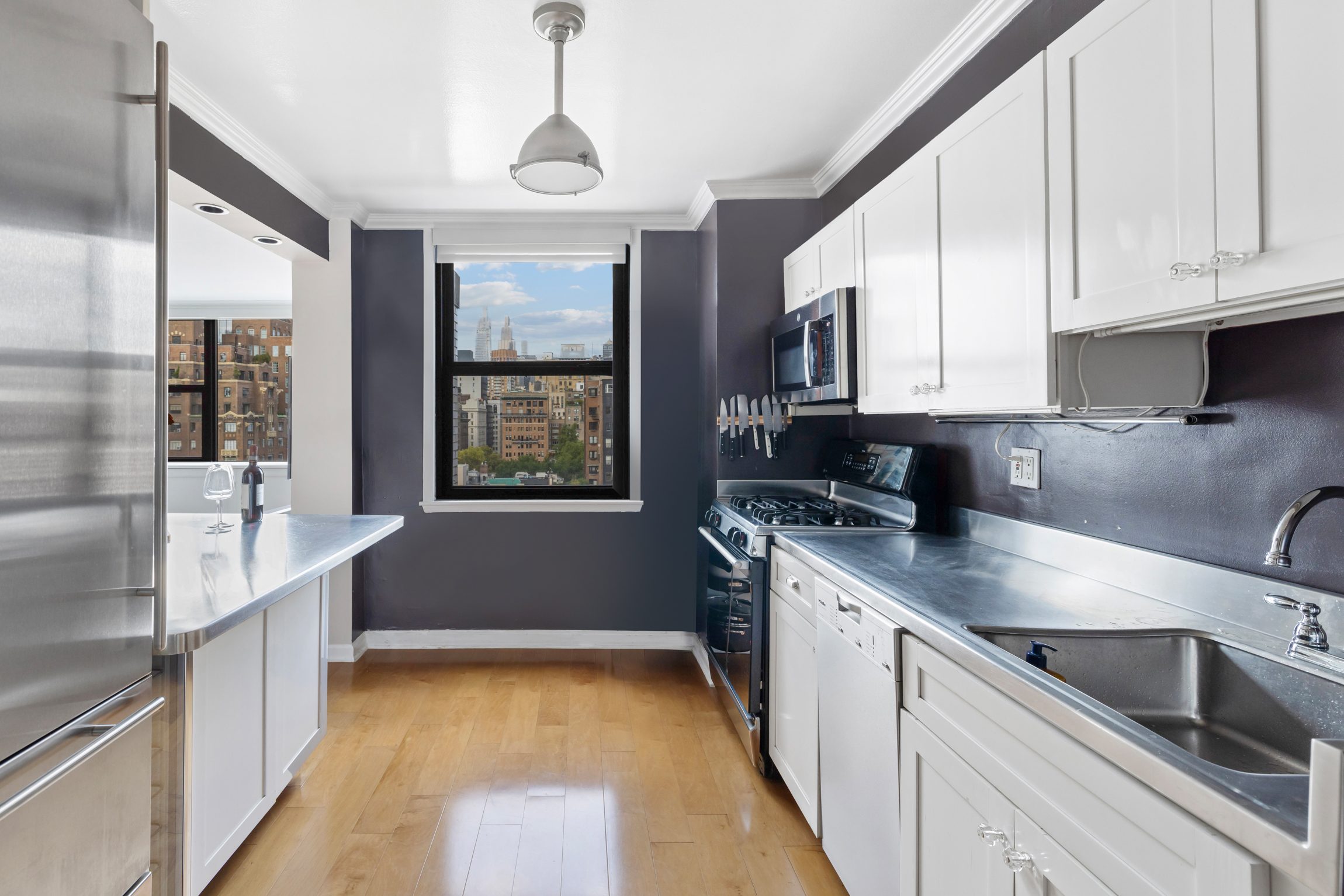 130 East 18th Street, Unit 14B Manhattan, NY 10003 - Photo 4 of 8 a kitchen with stainless steel appliances granite countertop a sink and cabinets