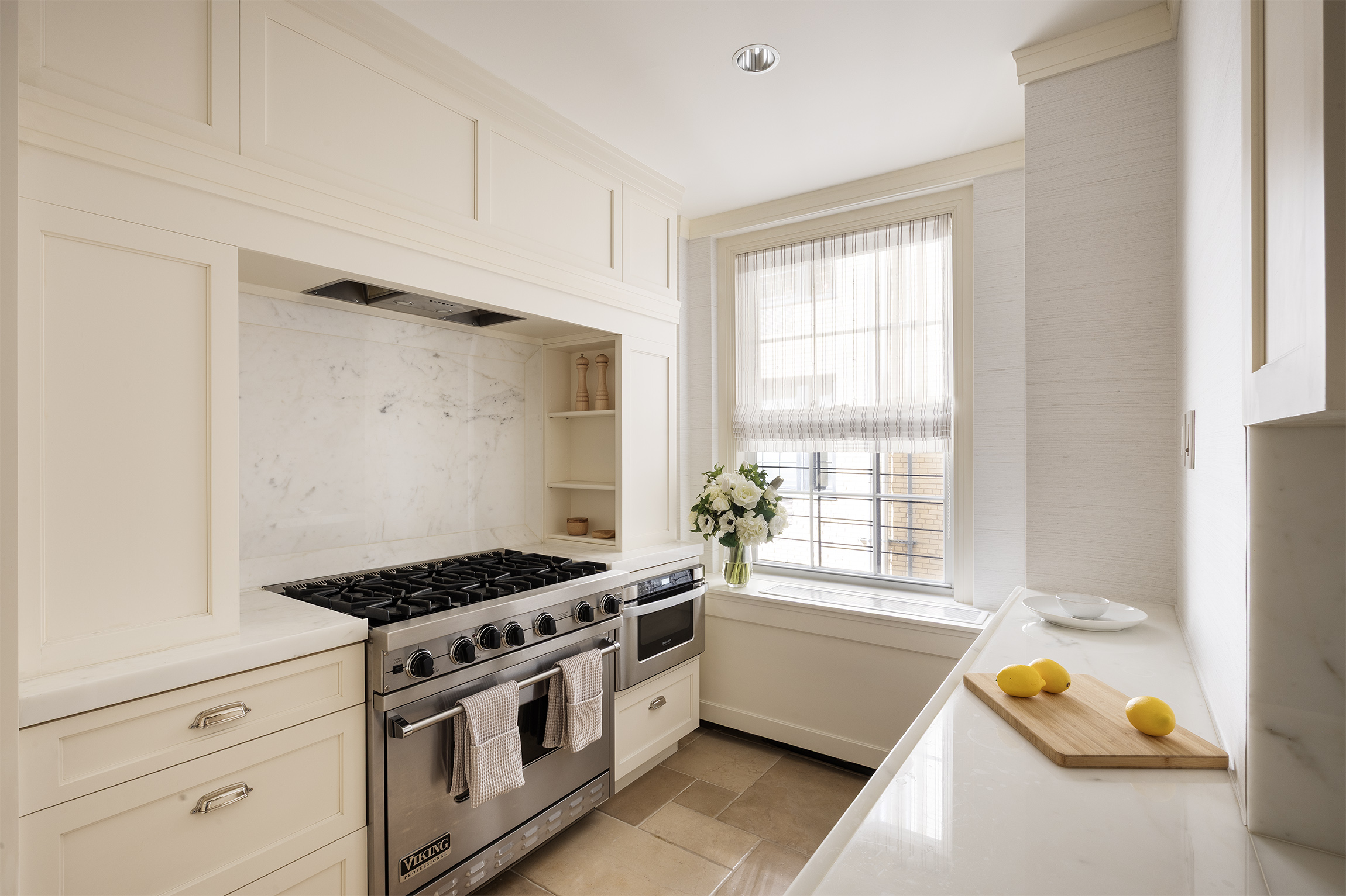 40 East 66th Street, Unit 9A Manhattan, NY 10065 - Photo 5 of 14 a kitchen with stainless steel appliances granite countertop a sink stove and white cabinets