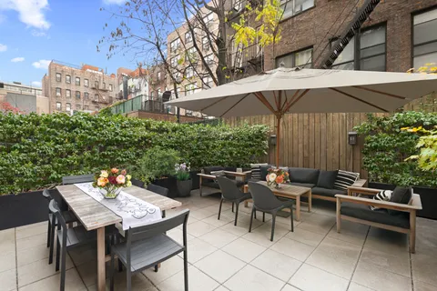 a view of a patio with a table and chairs under an umbrella
