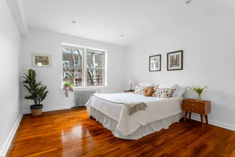 a bedroom with a bed and a potted plant