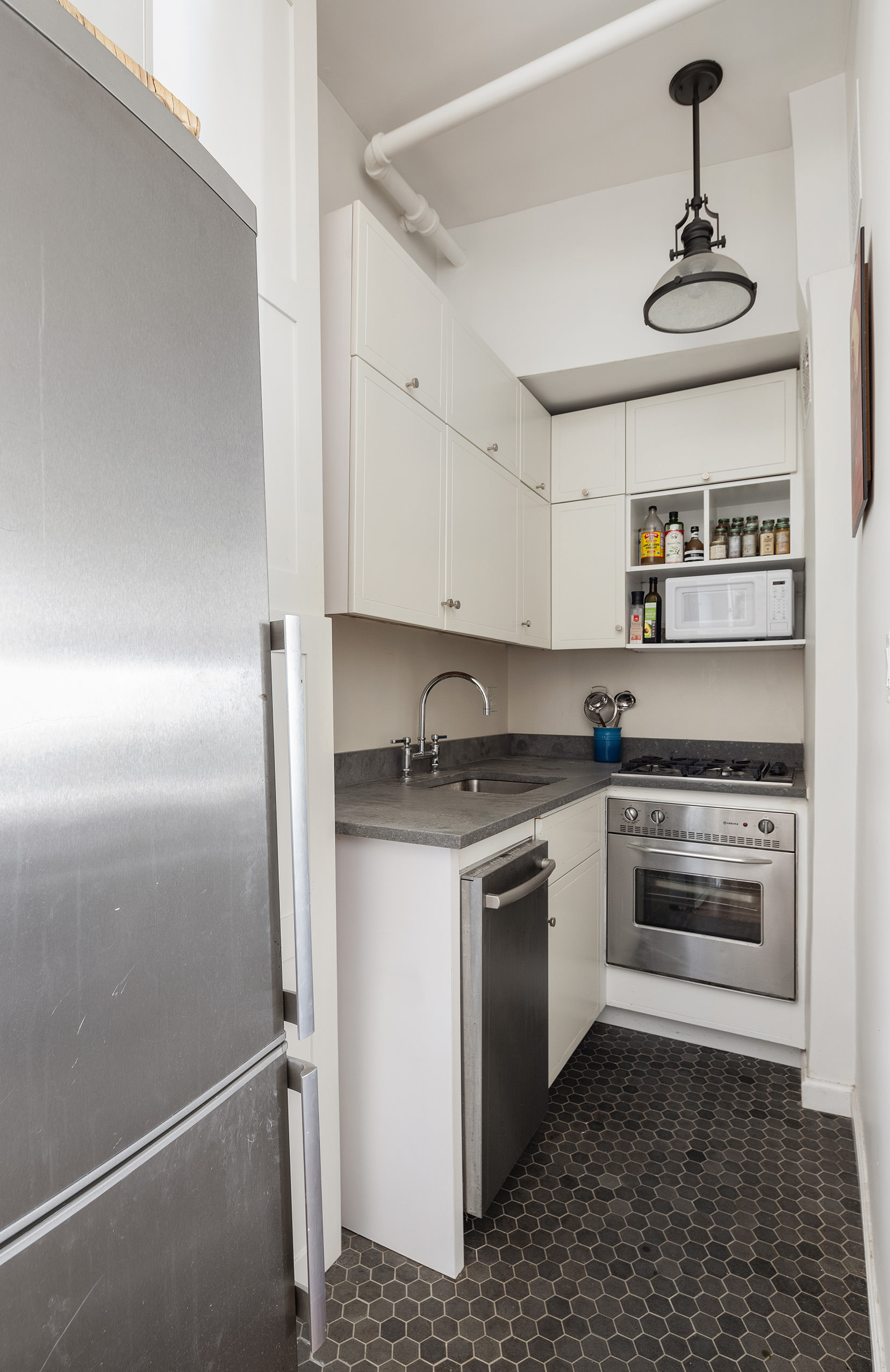 244 West 4th Street, Unit 5D Manhattan, NY 10014 - Photo 6 of 7 a kitchen with stainless steel appliances granite countertop a sink a stove and refrigerator