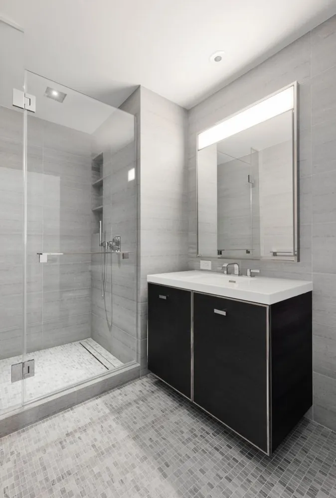 a bathroom with a sink mirror and shower