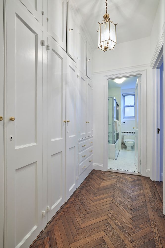 a view of a hallway with wooden floor and a kitchen