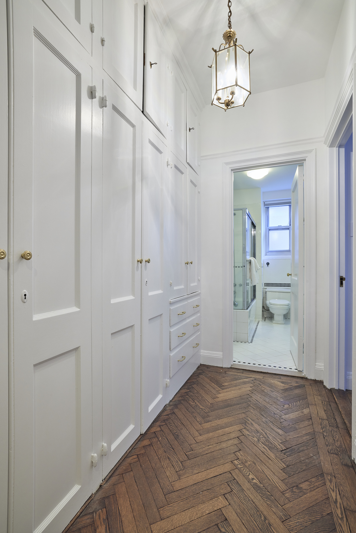 520 East 86th Street, Unit 2D Manhattan, NY 10028 - Photo 9 of 15 a view of a hallway with wooden floor and a kitchen