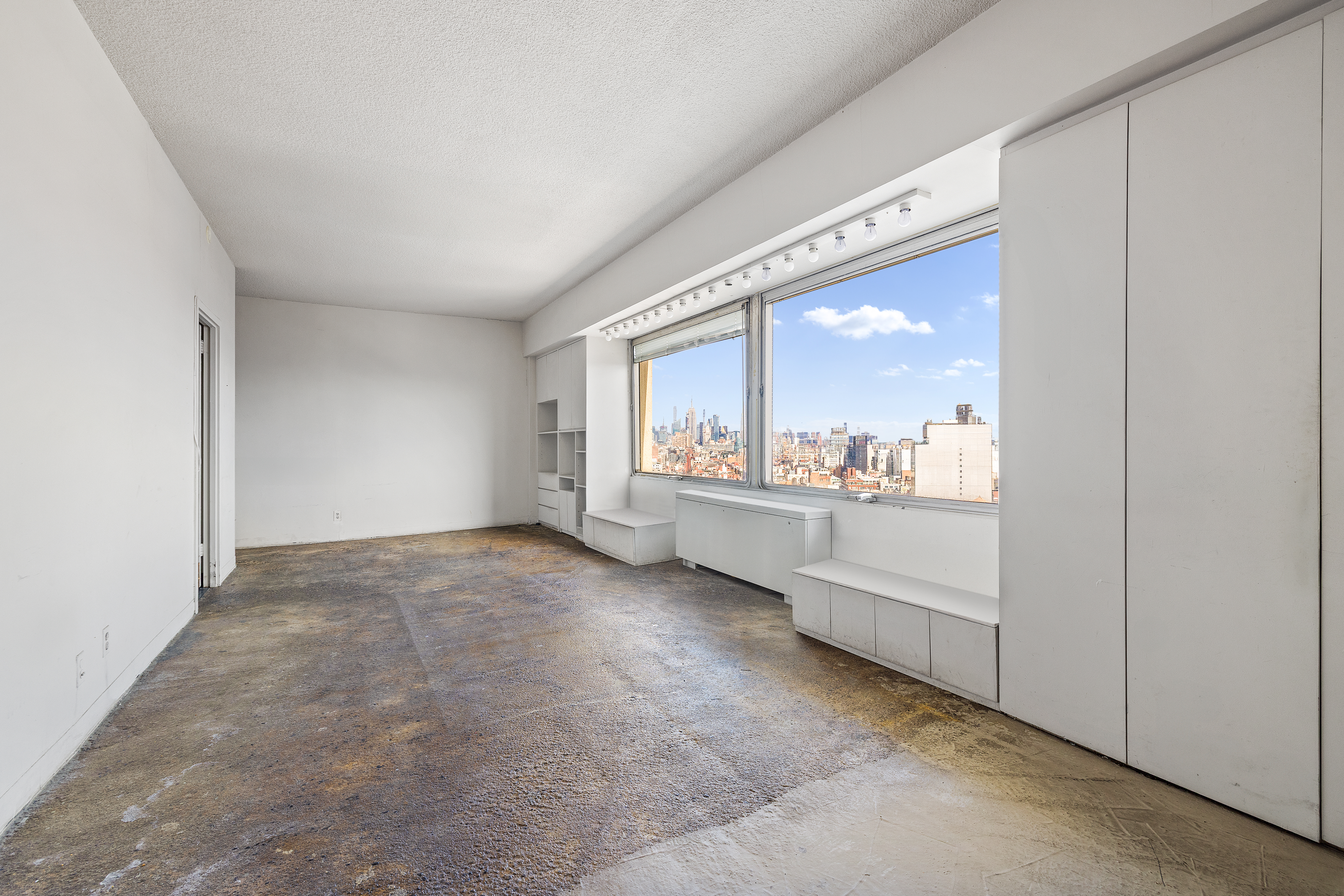 180 Park Row, Unit 25E Manhattan, NY 10007 - Photo 4 of 11 a view of a big room with windows and cabinet