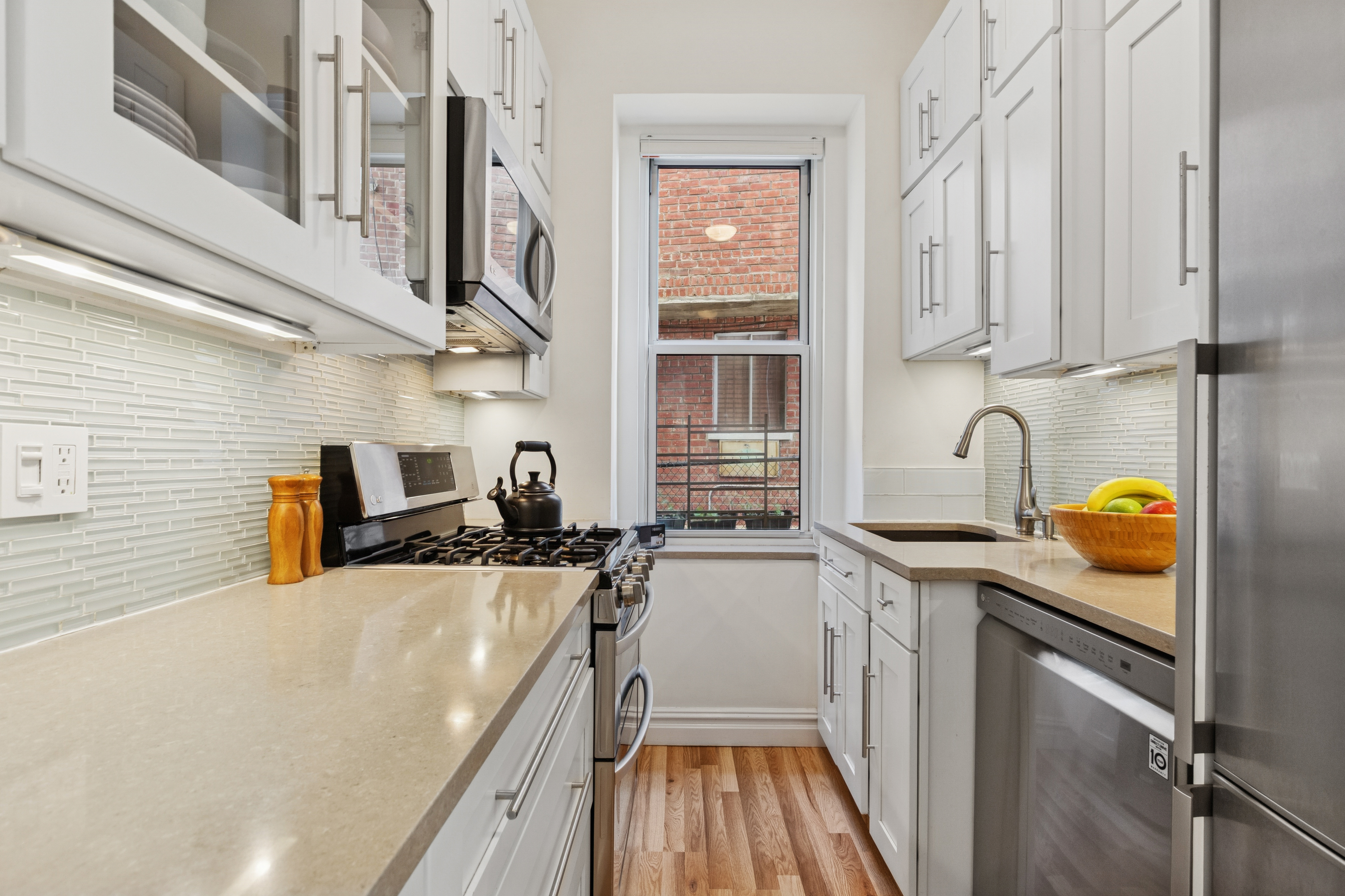 250 Cabrini Boulevard, Unit 1H Manhattan, NY 10033 - Photo 5 of 17 a kitchen with stainless steel appliances granite countertop a sink stove and cabinets