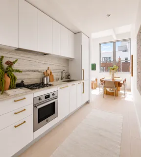 a kitchen with stainless steel appliances granite countertop a stove a sink and white cabinets