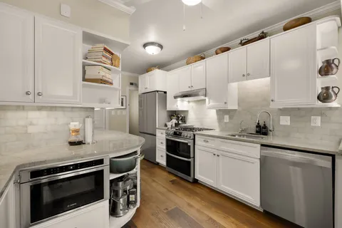 a kitchen with stainless steel appliances white cabinets and a sink