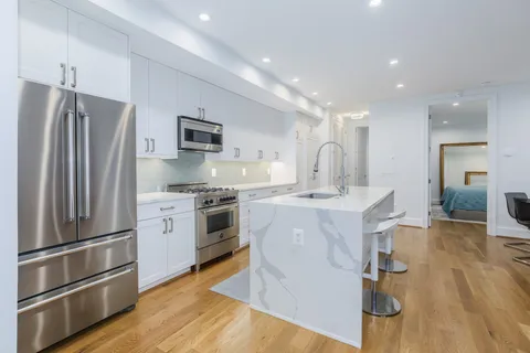 a kitchen with kitchen island a counter top space stainless steel appliances and cabinets