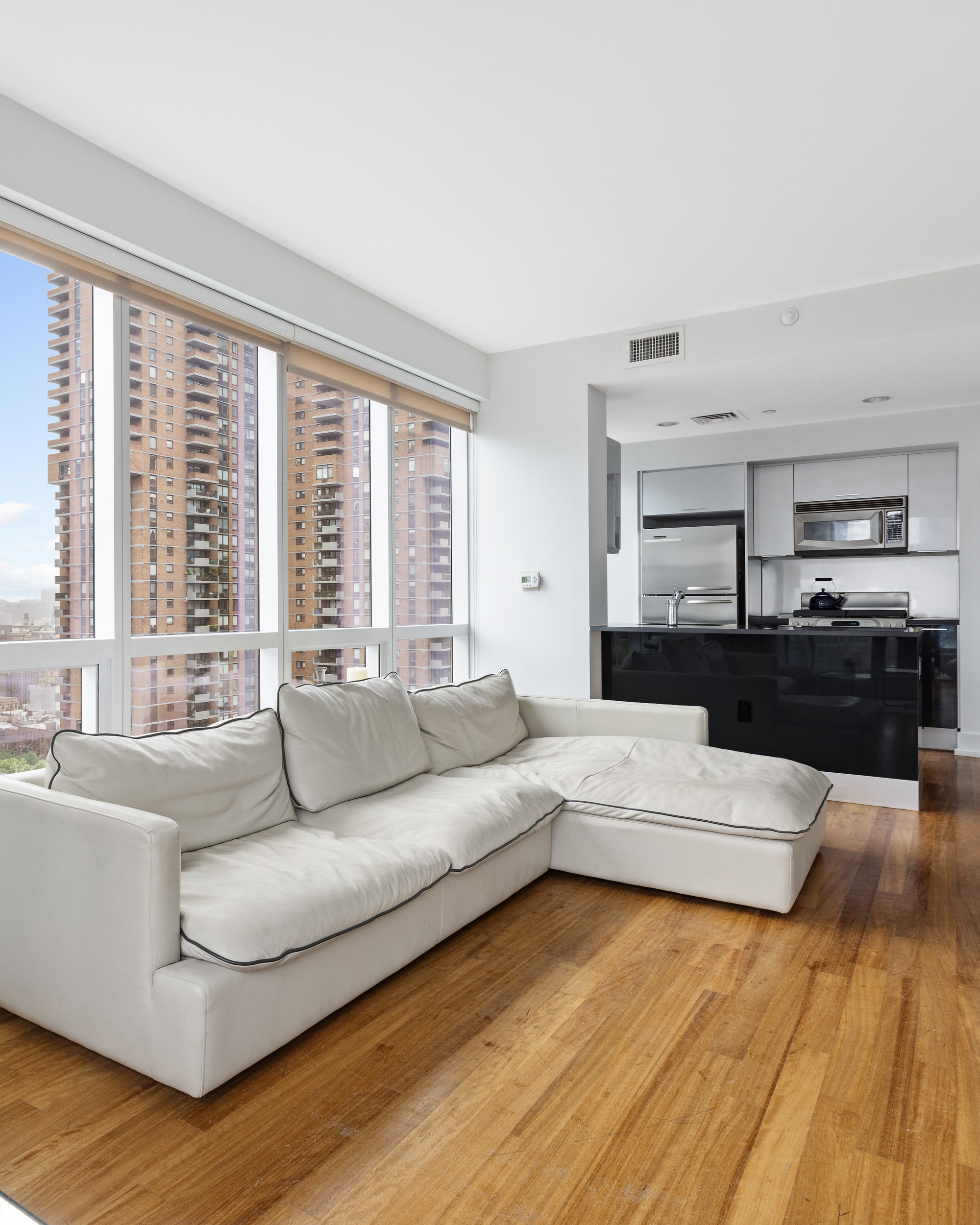 350 West 42nd Street, Unit 20L Manhattan, NY 10036 - Photo 5 of 11 a living room with furniture and a large window
