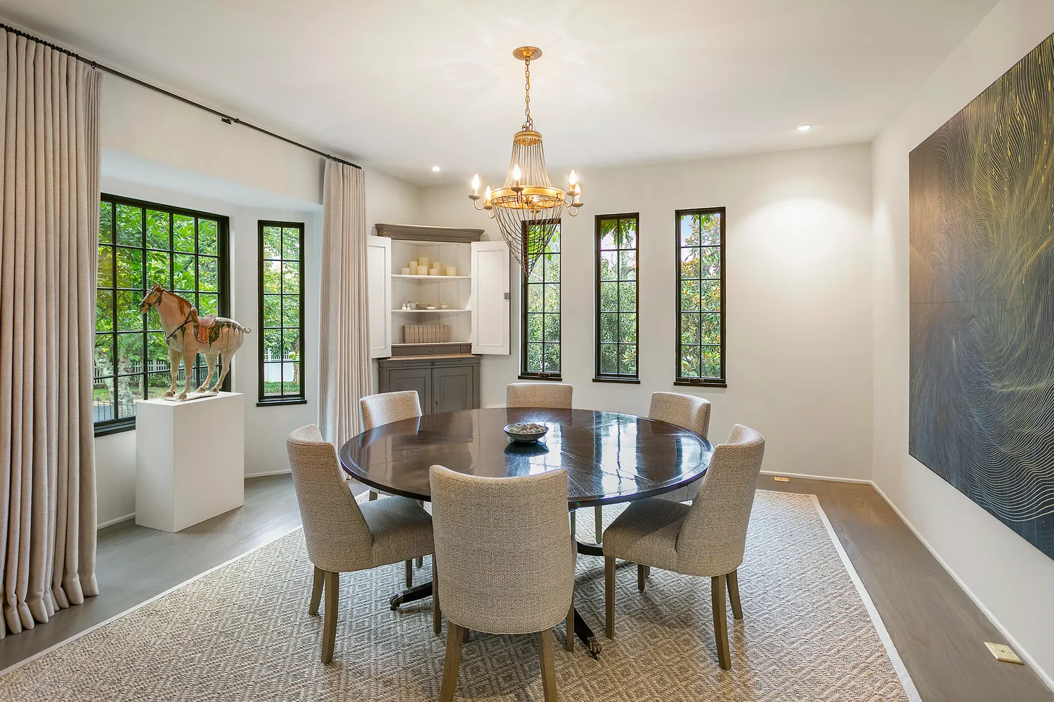 a dining room with furniture a chandelier and wooden floor