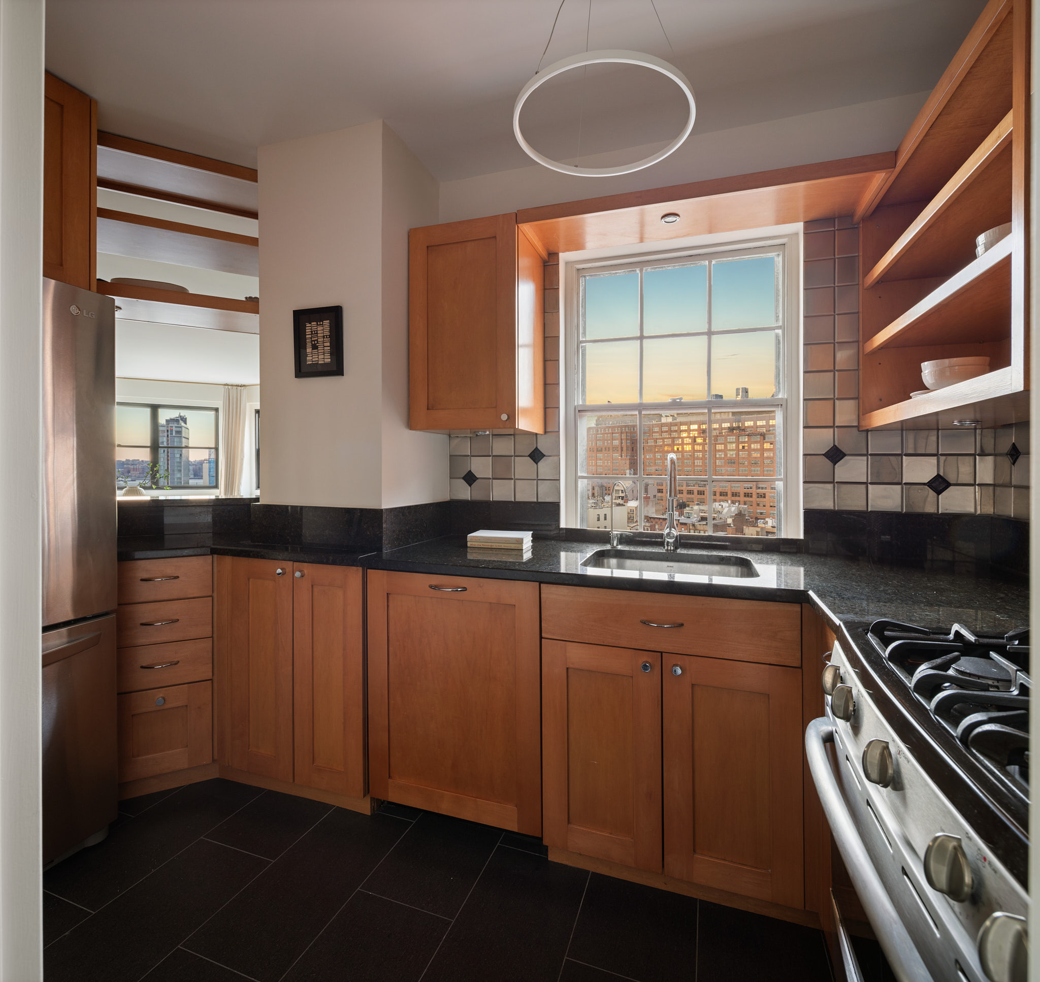 31 Jane Street, Unit 16G Manhattan, NY 10014 - Photo 10 of 20 a kitchen with stainless steel appliances granite countertop a sink and a stove