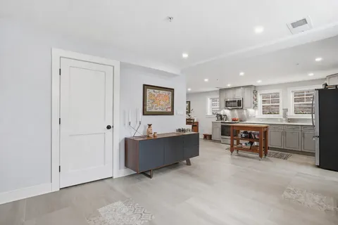 a living room with furniture and a dining table with kitchen view