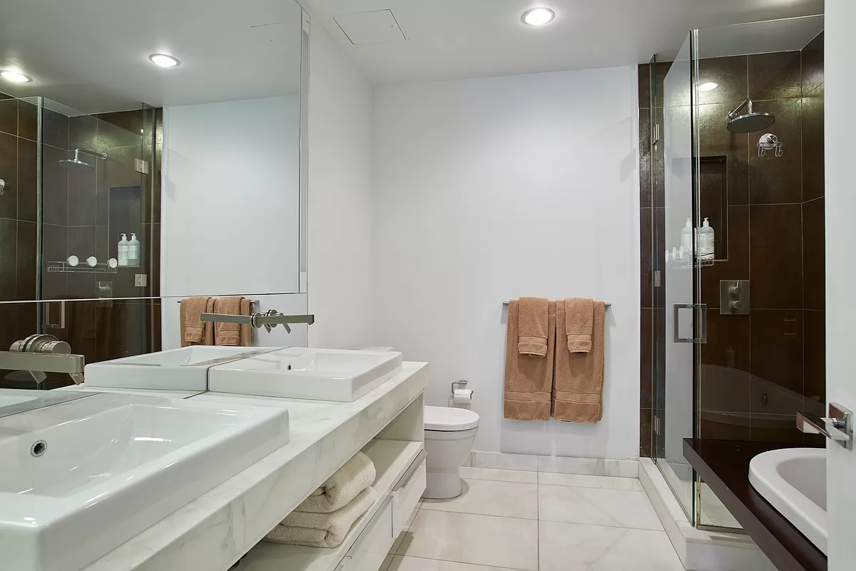 133 West 22nd Street, Unit 12B Manhattan, NY 10011 - Photo 5 of 12 a bathroom with a sink a toilet and shower