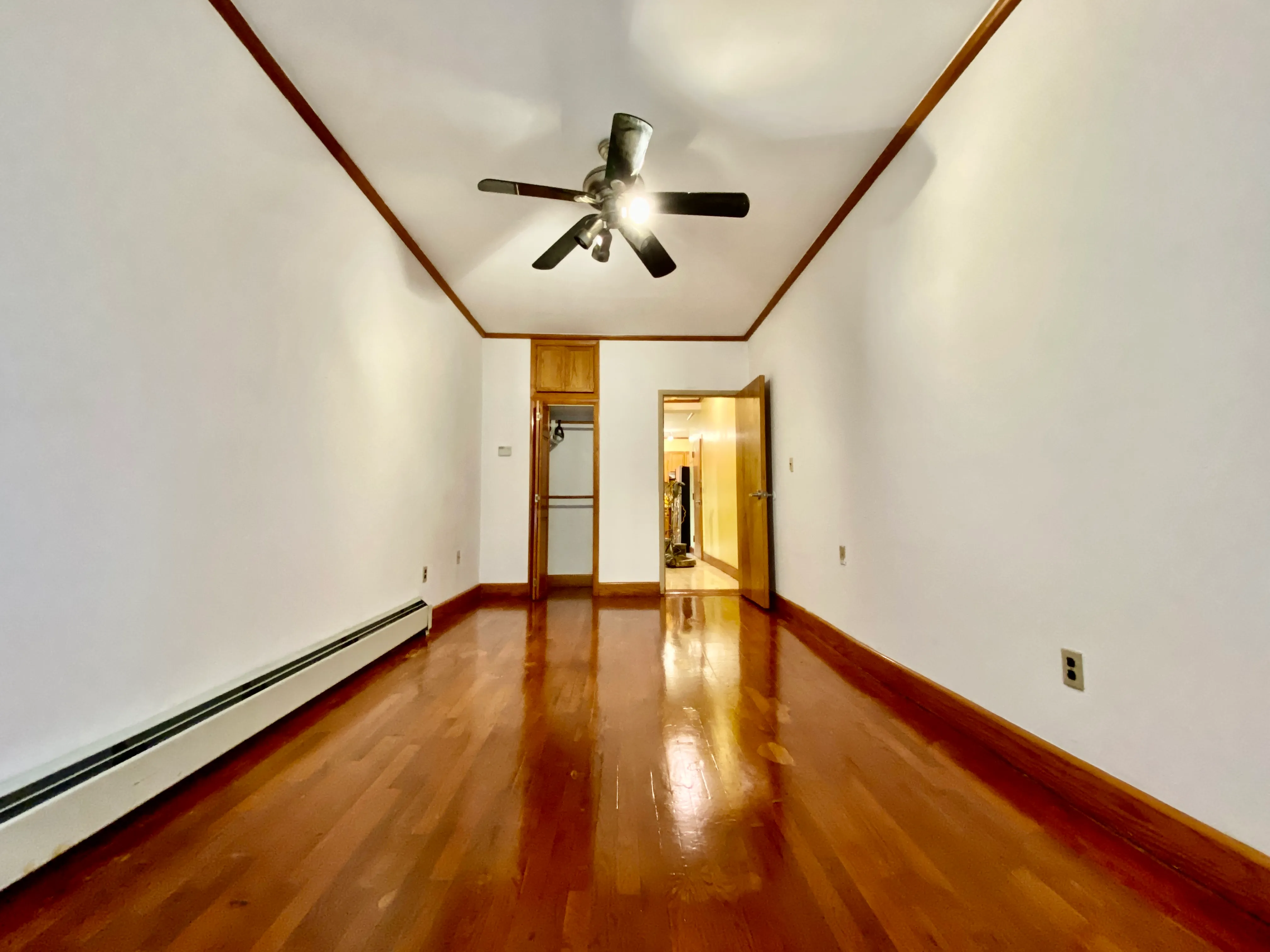 423 Lincoln Place, Unit 1 Brooklyn, NY 11238 - Photo 2 of 4 a view of empty room with wooden floor and fan