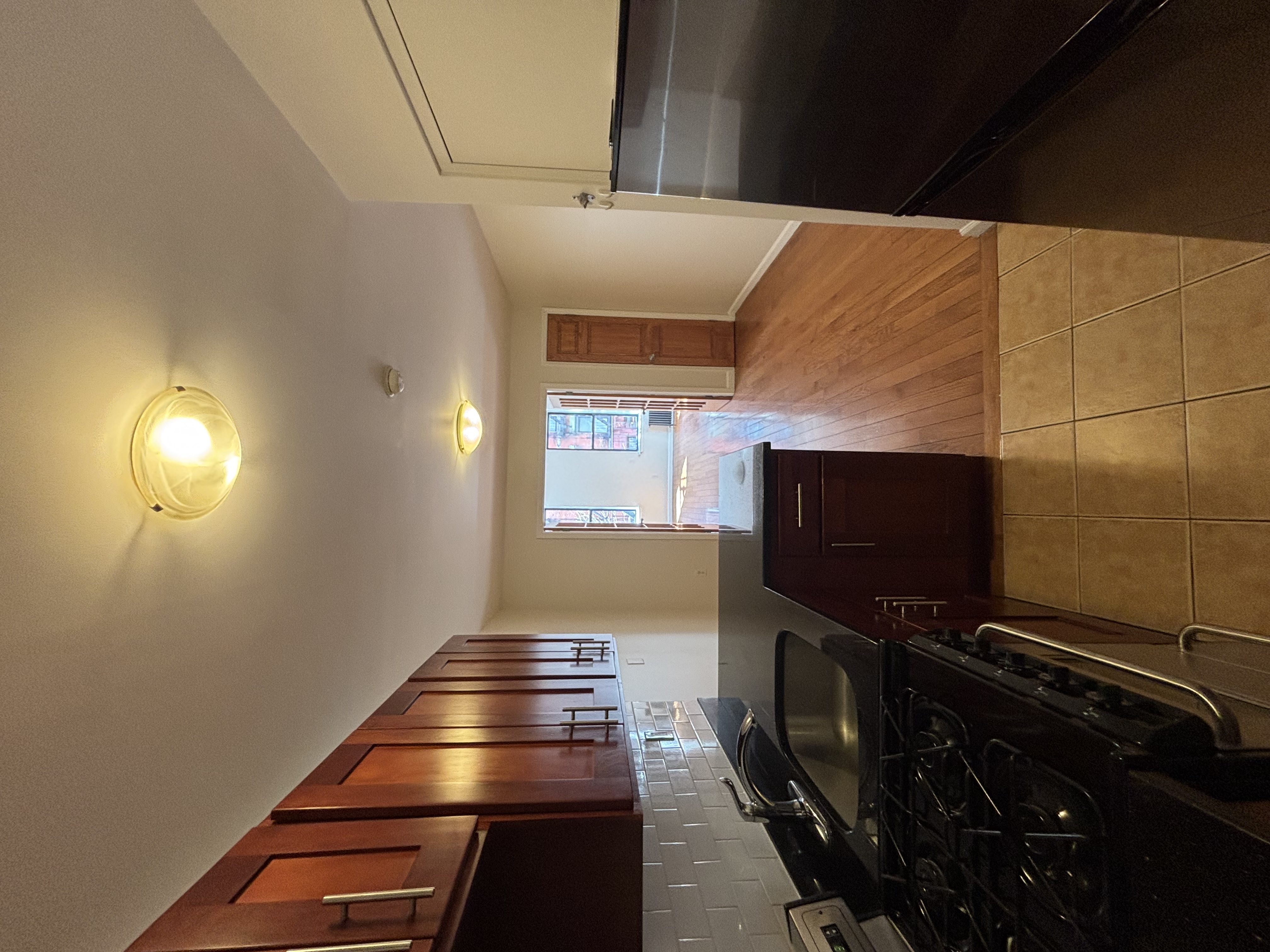 99 St Marks Place, Unit 4B Manhattan, NY 10009 - Photo 7 of 10 a kitchen with granite countertop stove and cabinets