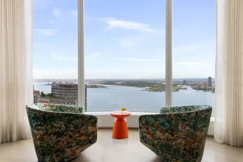a view of water from a balcony with outdoor seating