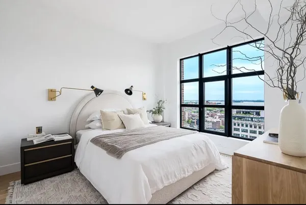 a bedroom with a bed and a large window