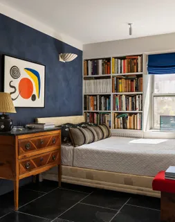 a bedroom with a bed and a book shelf
