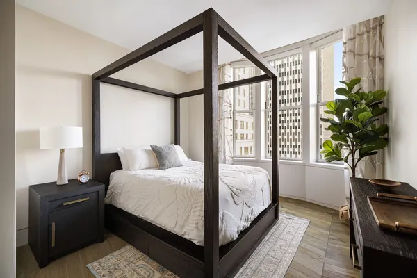 a bedroom with a bed lamp and a window