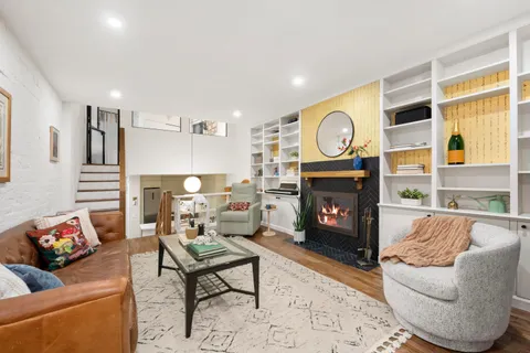 a living room with furniture a fireplace and a large window