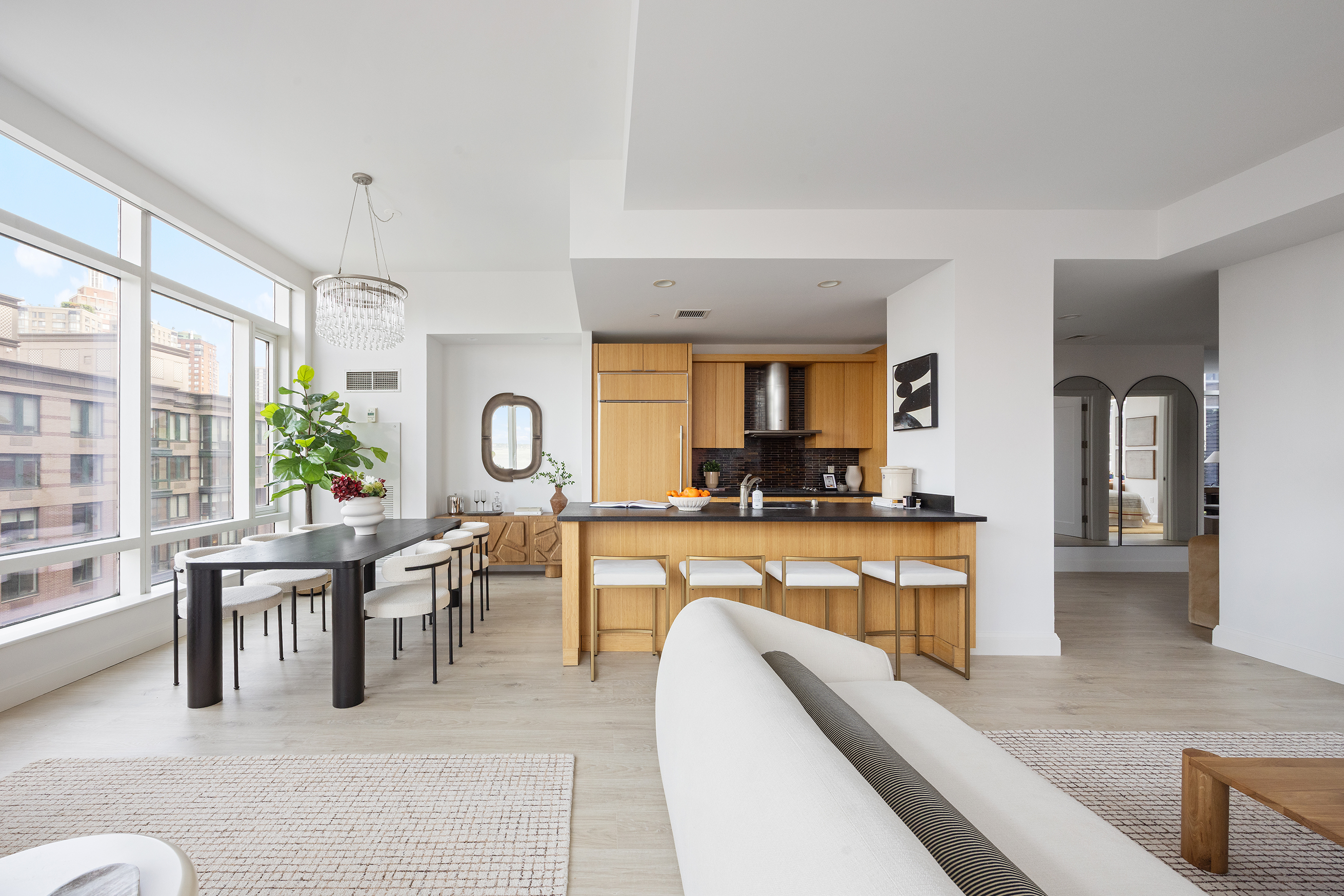 a living room with furniture a large window and a dining table