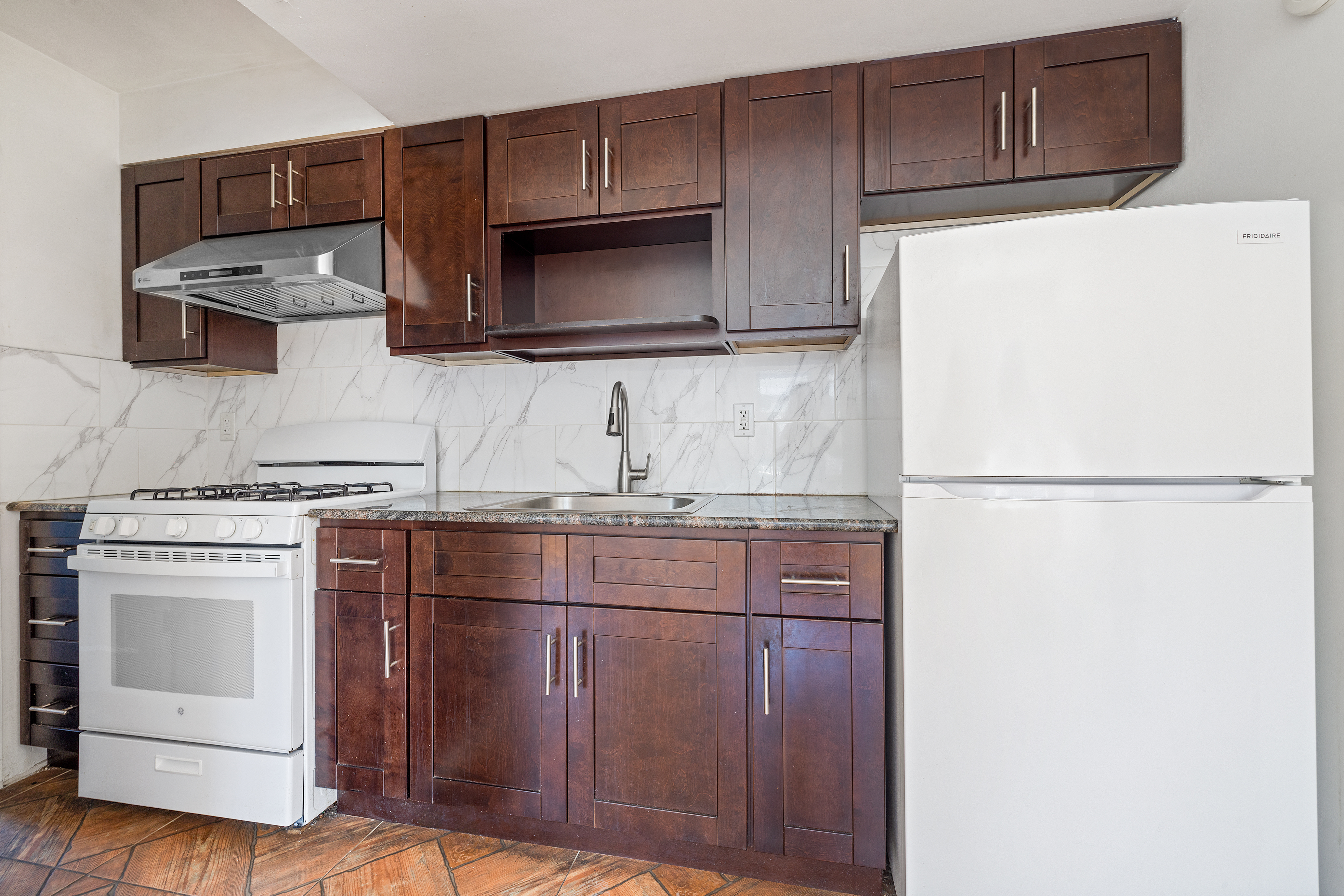 63-20 Haring Street, Unit 2R Queens, NY 11374 - Photo 9 of 10 a kitchen with stainless steel appliances granite countertop a refrigerator and a stove top oven