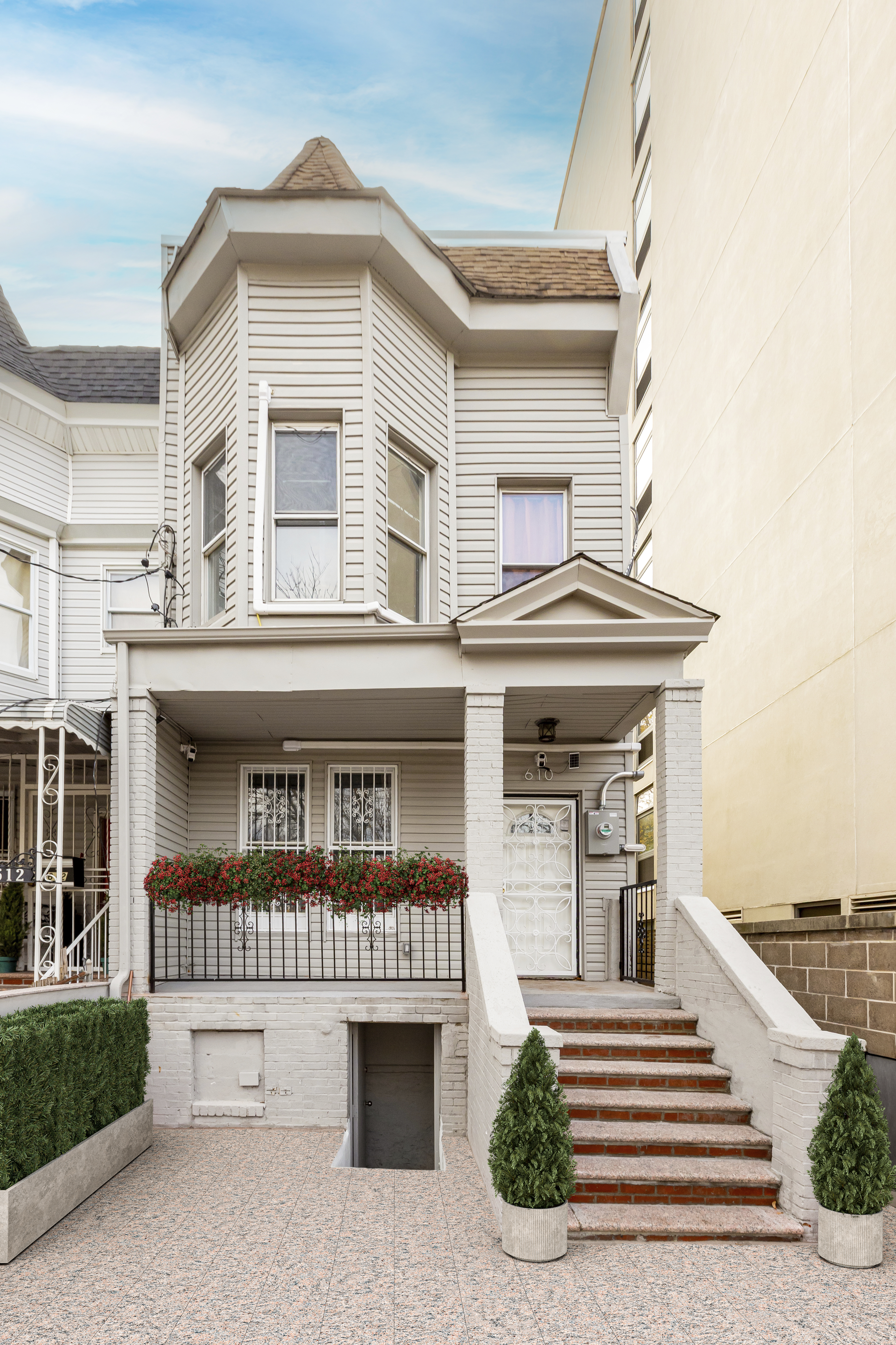 610 East 181st Street Bronx, NY 10457 - Photo 11 of 13 a view of a brick house with large windows and a small yard