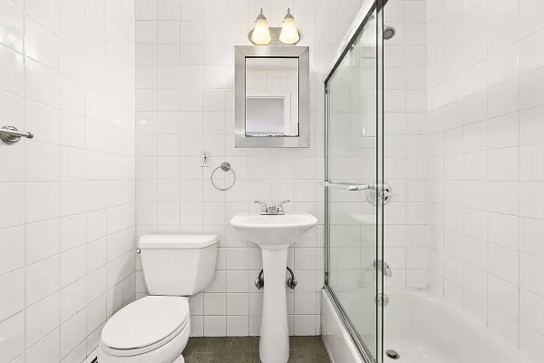 a bathroom with a sink a toilet and shower