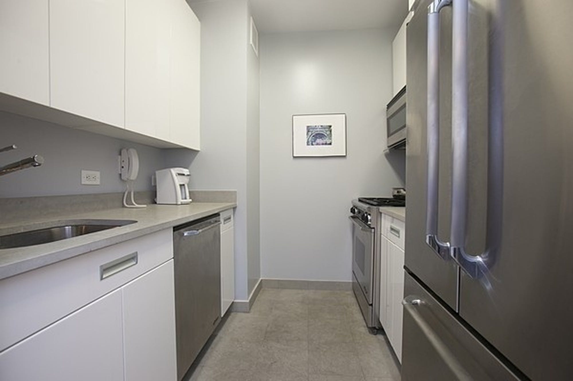 99 John Street, Unit 926 Manhattan, NY 10038 - Photo 4 of 12 a kitchen with a refrigerator and a stove