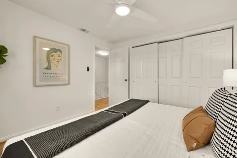 a bedroom with a bed and a painting on the wall