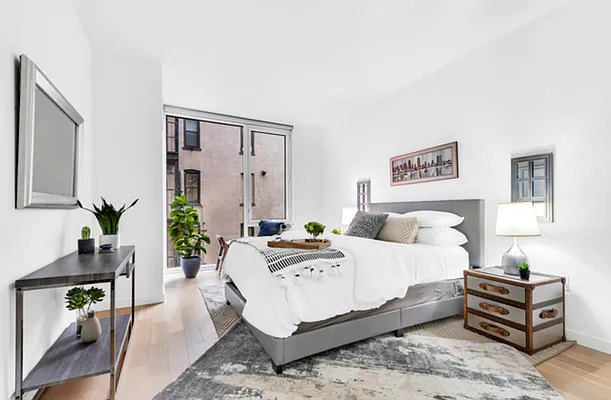 540 West 49th Street, Unit 206N Manhattan, NY 10019 - Photo 5 of 14 a bedroom with a bed a table and chair