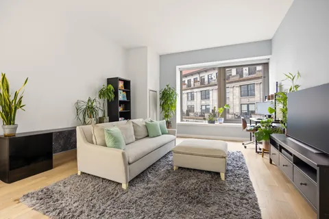 a living room with furniture flat screen tv and a large window