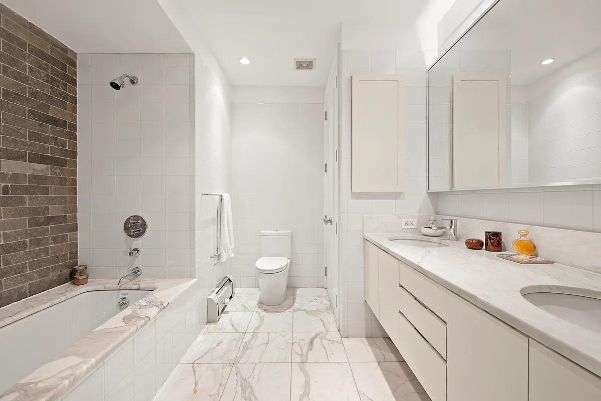 102 Fulton Street, Unit 2E Manhattan, NY 10038 - Photo 5 of 7 a spacious bathroom with a tub sink and mirror