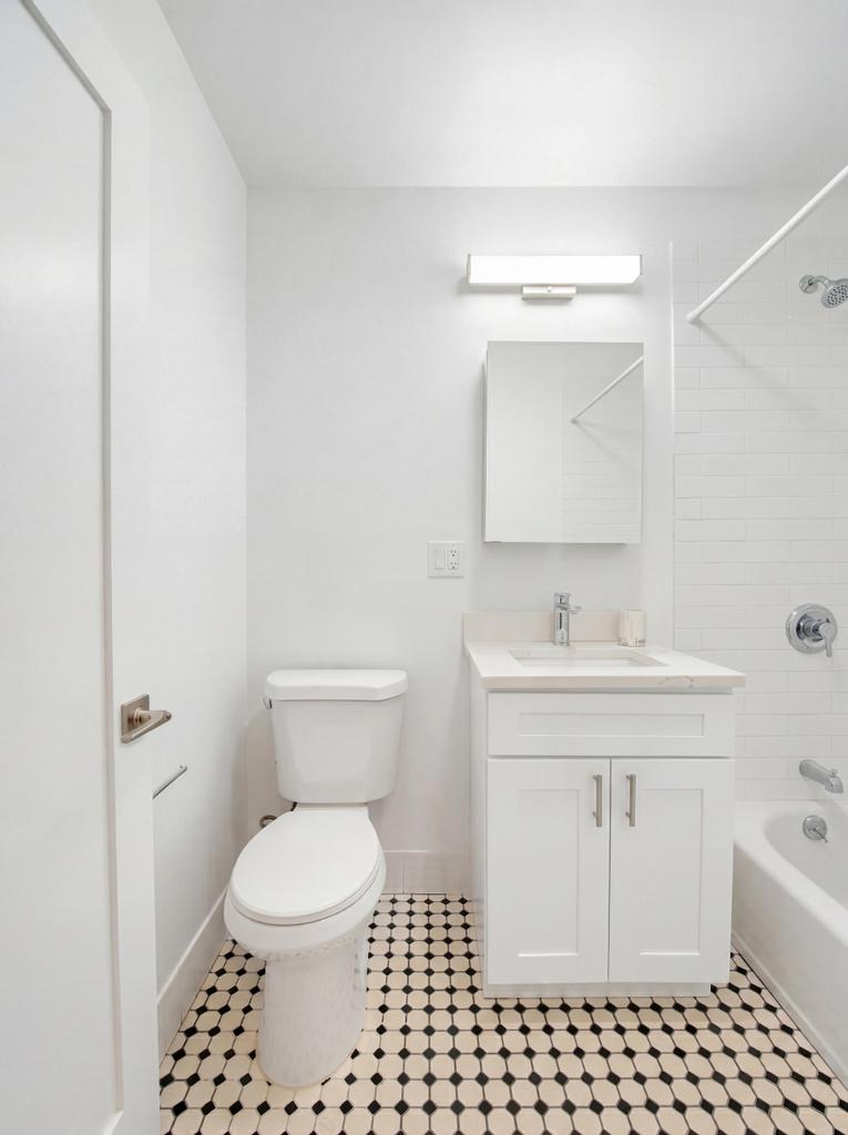 231 East 60th Street, Unit 5 Manhattan, NY 10022 - Photo 3 of 11 a bathroom with a sink toilet and shower