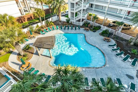 a front view of a building with a garden and plants